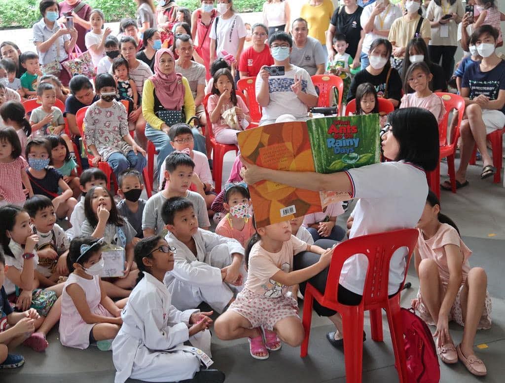 孙雪玲为区内的孩子们阅读自己撰写的儿童图书《下雨天蚂蚁做什么》