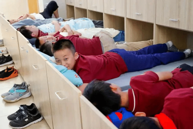 小学生在“抽屉床”上睡午觉。