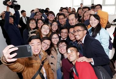 财政部长王瑞杰（中）在清华大学经济管理学院同出席对话会的新加坡留学生合照留念。（财政部提供）