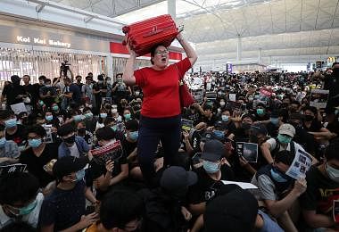 大妈扛行李逃难，在香港机场杀出一条血路的照片在网络上爆红。本地媒体报道说，大妈原来是新加坡人。