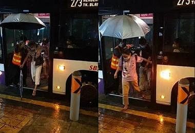 巴士车长为乘客撑伞。（STOMP视频截图）