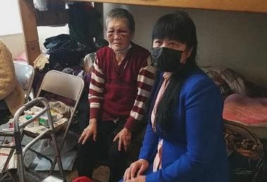 脸部依然淤青未消肿的谢萧珍奶奶（左）与看望她的当地华侨。（互联网）