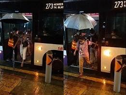 巴士车长为乘客撑伞。（STOMP视频截图）