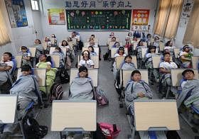 午休时间，中国浙江雷甸镇中心小学的学生躺在折叠椅上睡午觉